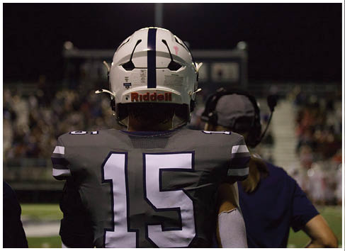A football player running on the field. Description generated by AI
