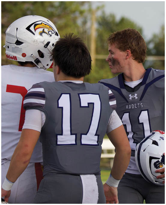 A group of football players wearing black and white uniforms. Description generated by AI