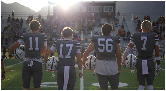 A group of football players on a field. Description generated by AI