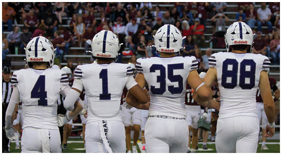 A group of football players on a field. Description generated by AI