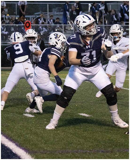 A group of football players wearing black and white uniforms. Description generated by AI
