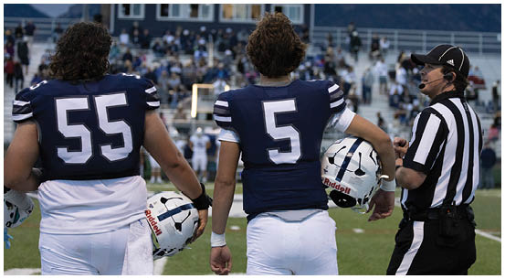 A group of football players on a field. Description generated by AI