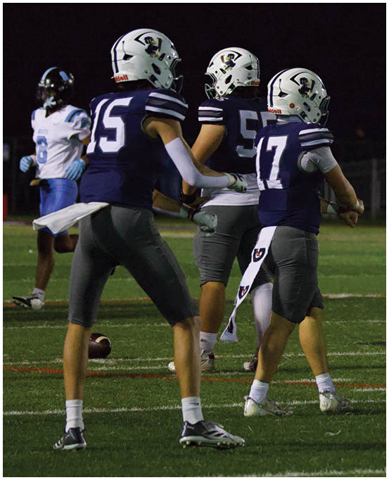 A group of football players wearing black and white uniforms. Description generated by AI
