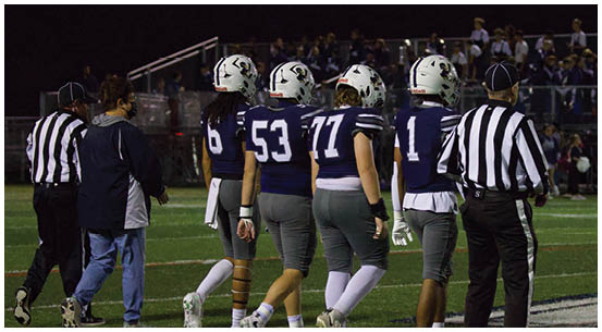 A group of football players on a field. Description generated by AI