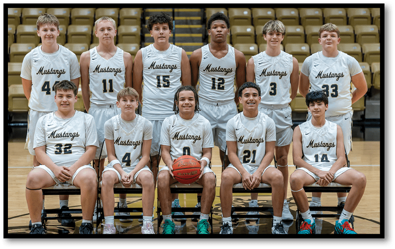 A group of young people wearing white basketball uniforms with “Mustangs" written on them pose together on a basketball court with some sitting on benches and others standing behind. Description generated by AI