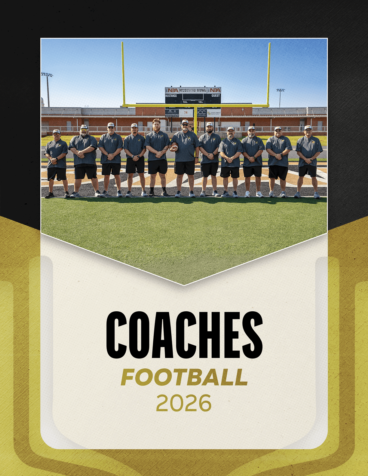 A group of adults wearing matching dark shirts and shorts stand in a line on a football field with goalposts and a scoreboard in the background above the text reading coaches football 2026. Description generated by AI