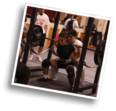 A person wearing athletic clothing and knee sleeves is performing a squat with a weighted barbell on their shoulders while another person closely spots them in a gym setting. Description generated by AI