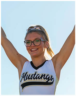 A person wearing glasses and a headband with a pattern is shown from the eyes up against a clear blue sky. Description generated by AI