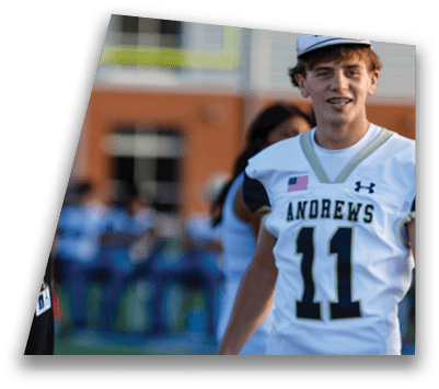 People in football uniforms are positioned on a field preparing for a play during a game. Description generated by AI