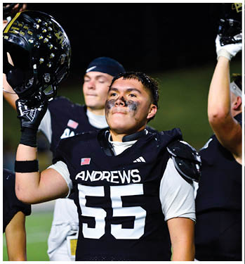 Two people are shown with one in the foreground having black face paint under their eyes and the other in the background wearing a dark headband with a white swoosh logo. Description generated by AI