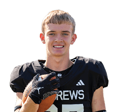 A person wearing a black football jersey and glove is holding a football and smiling. Description generated by AI