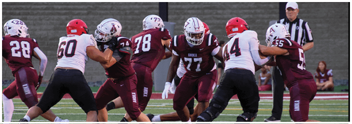 A football game is taking place on a field with players wearing blue and white uniforms. Description generated by AI