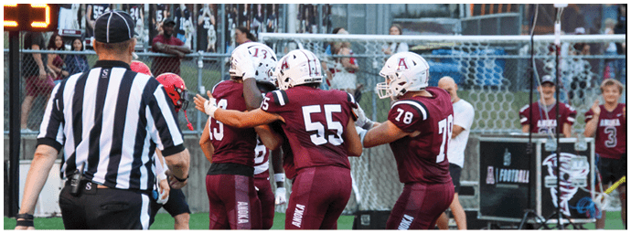 A group of football players on a field. Description generated by AI