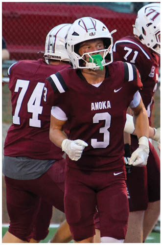 A football player wearing a blue and red jersey. Description generated by AI