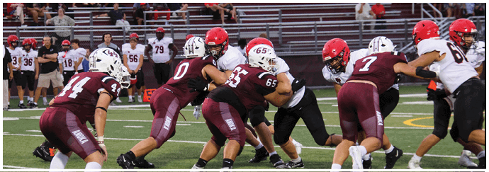 A football game is taking place on a field with players wearing blue and white uniforms. Description generated by AI