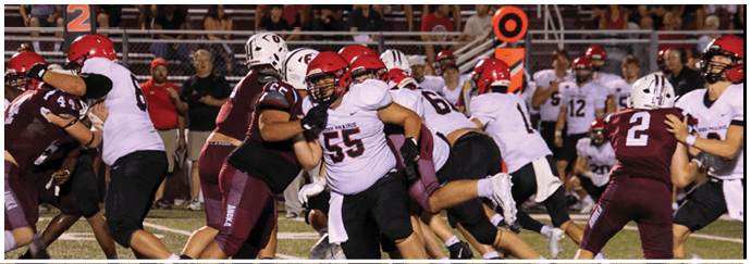A football game is taking place on a field with players wearing blue and white uniforms. Description generated by AI