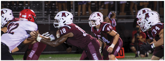 A group of football players on a field. Description generated by AI