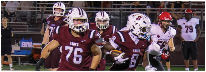 A football game is taking place on a field with players wearing blue and white uniforms. Description generated by AI