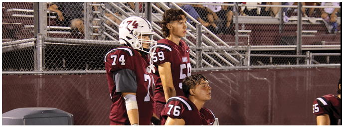 A group of football players on a field. Description generated by AI