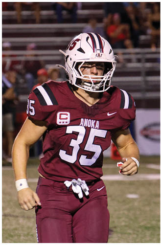 A football player wearing a blue and red jersey. Description generated by AI