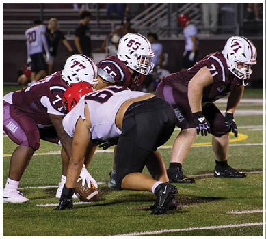 A football game is taking place with a group of men on the field. Description generated by AI
