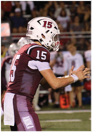 A football player wearing a blue and red jersey. Description generated by AI
