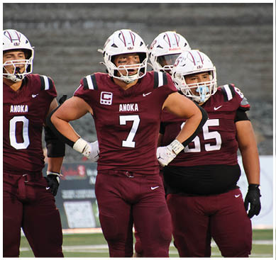 A football game is taking place with a group of men on the field. Description generated by AI
