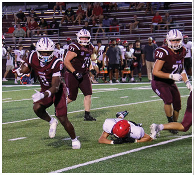 A football game is taking place with a group of men on the field. Description generated by AI