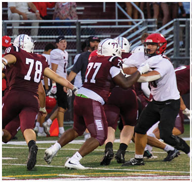 A football game is taking place with a group of men on the field. Description generated by AI