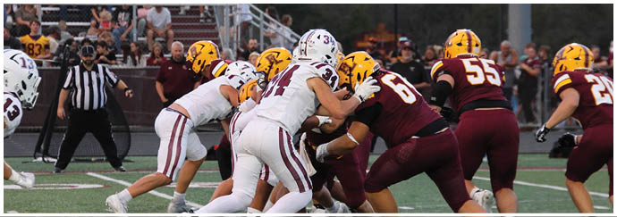 A football game is taking place on a field with players wearing blue and white uniforms. Description generated by AI