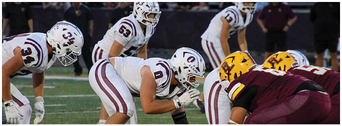 A group of football players on a field. Description generated by AI