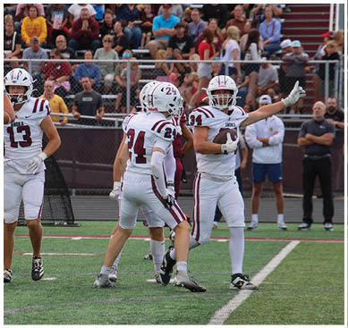 A football game is taking place with a group of men on the field. Description generated by AI