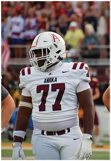A football player wearing a blue and red jersey. Description generated by AI
