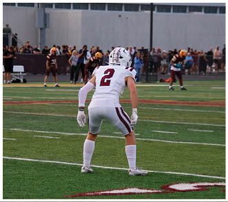 A football player wearing a blue and red jersey. Description generated by AI