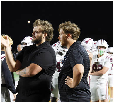A football game is taking place with a group of men on the field. Description generated by AI