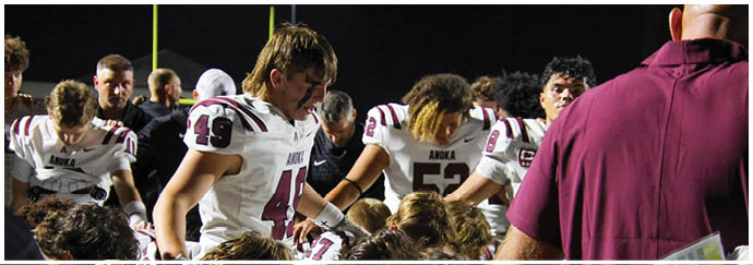 A football game is taking place on a field with players wearing blue and white uniforms. Description generated by AI