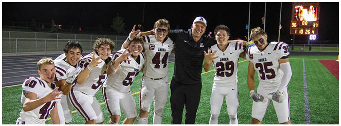 A group of football players on a field. Description generated by AI