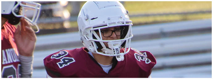 A football player wearing a blue and white uniform. Description generated by AI