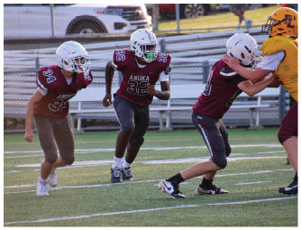 A group of football players on a field. Description generated by AI