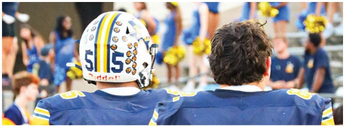 A football player wearing a blue and white uniform. Description generated by AI