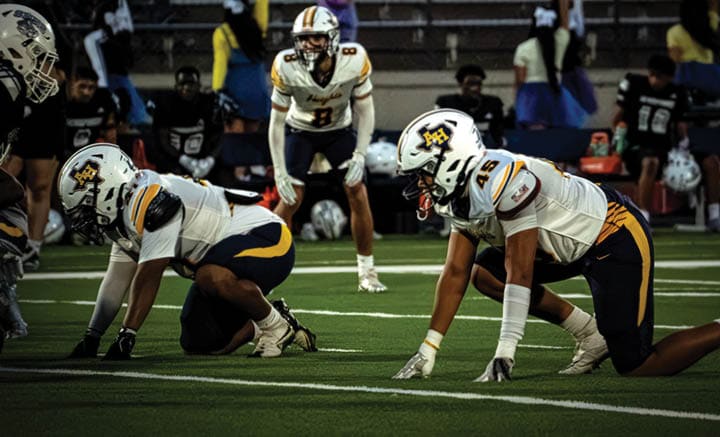 A group of people are kneeling on a field, possibly in a football game. AI generated content