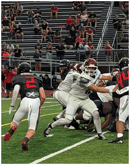 A football player wearing a black jersey with the number 11 on it. Description generated by AI