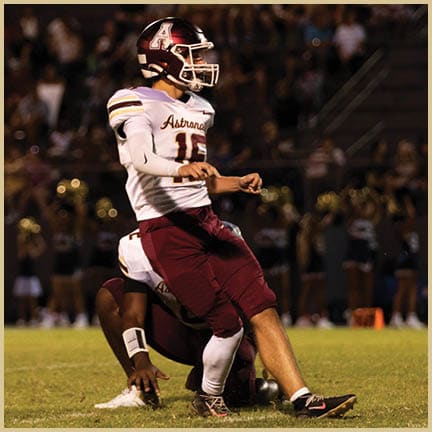 A football player is kicking a football on a field. Description generated by AI