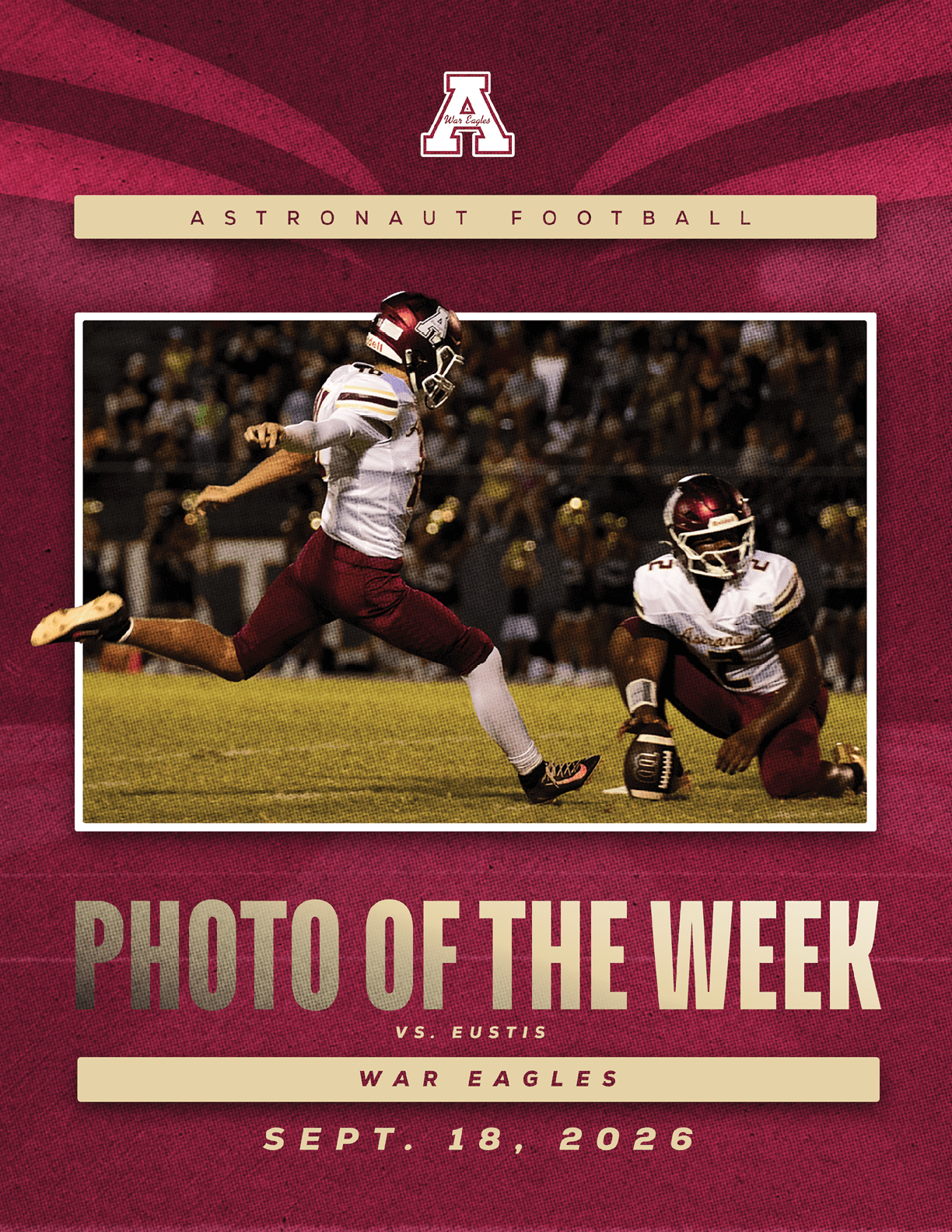 Two football players in white and maroon uniforms are on a field with one kicking a football held by the other during a nighttime game. Description generated by AI