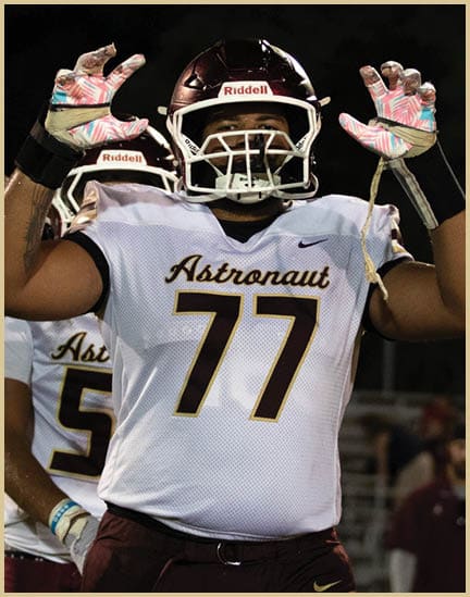 A football player wearing a black jersey with the number 11 on it. Description generated by AI