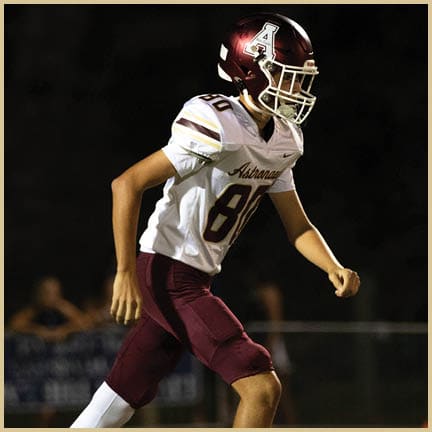 A football player is kicking a football on a field. Description generated by AI