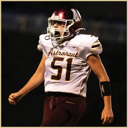 A football player is kicking a football on a field. Description generated by AI