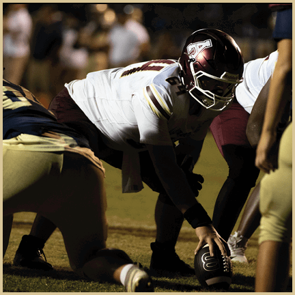 A football player is kicking a football on a field. Description generated by AI