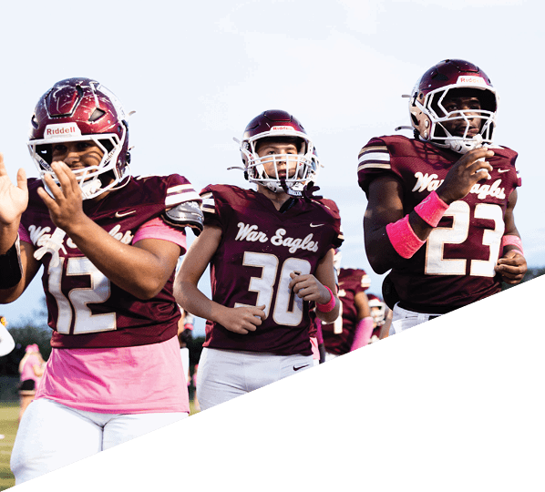 A football player is kneeling on the field, holding his helmet in his hands. AI generated content