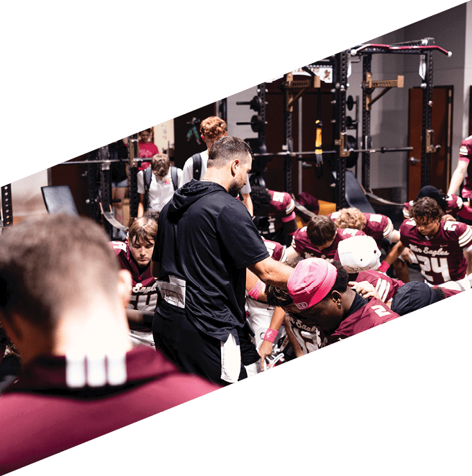A football team is gathered around a coach, listening to his instructions. AI generated content